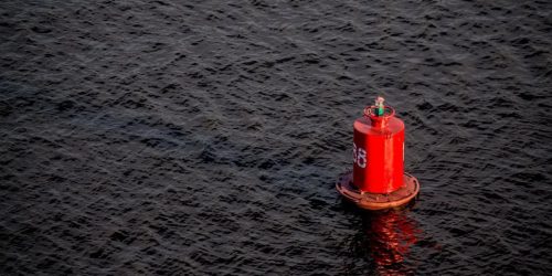 red-buoy-floating-on-body-of-water